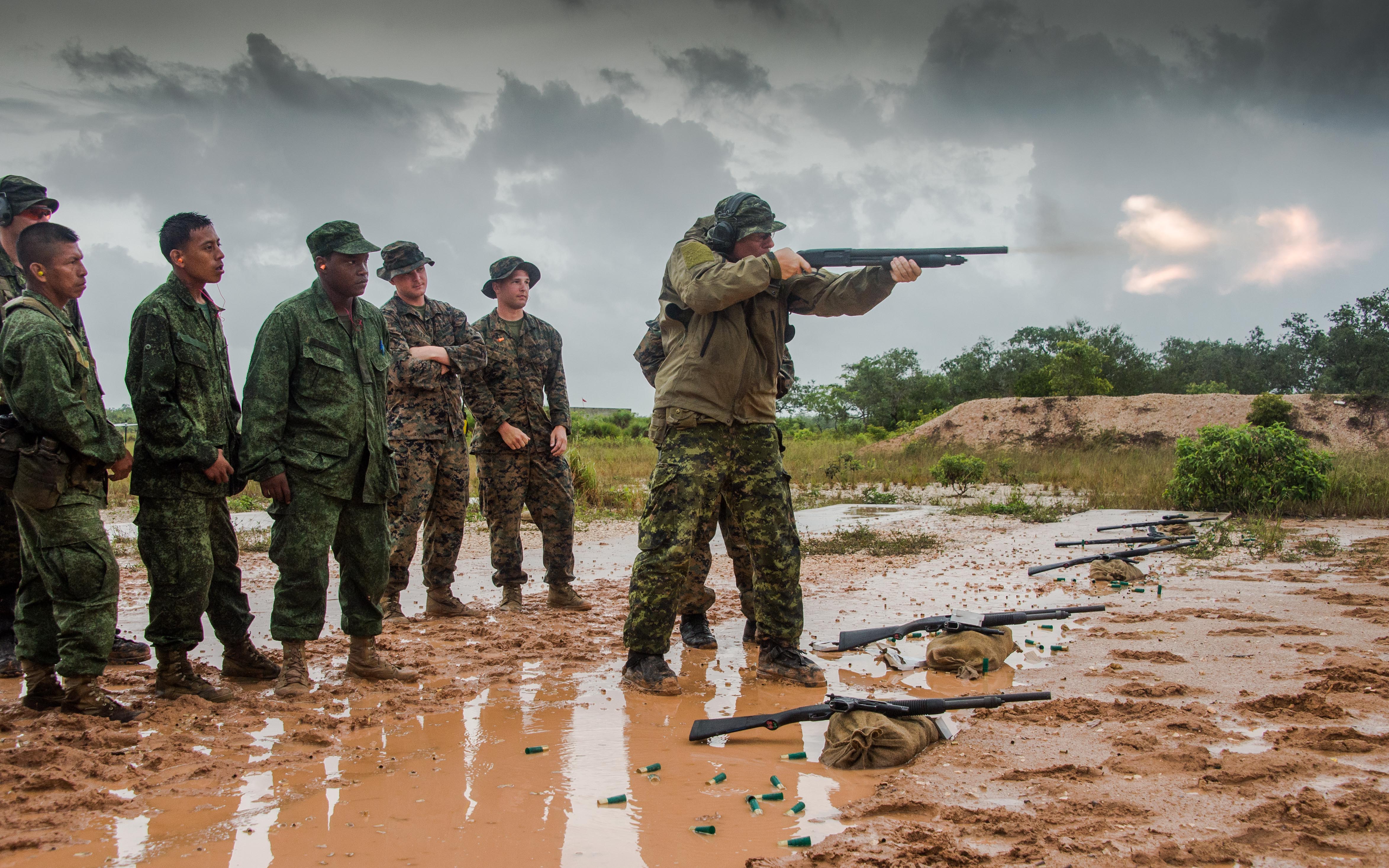 Belize. 18 June 2015 - Warrant Officer Jocelyn Roy from the Royal 22e Regiment, provides a shotgun demonstration for the soldiers from the Belize Defence Force and members of the United States Marine Corps participating in marksmanship shotgun training during phase II of Exercise TRADEWINDS 15. (Photo: Sgt Yannick Bédard, Canadian Forces Combat Camera)